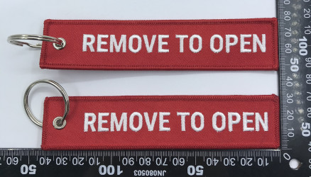 Red REMOVE TO OPEN keychain – Aircraft safety tag – June 2025